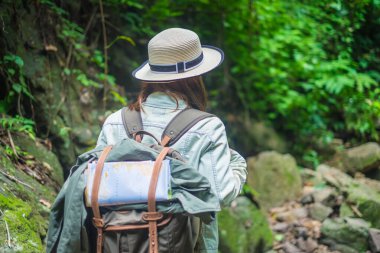 Sırt çantası ormanda duran Asyalı kadınların arkası. 