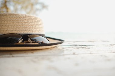 seyahat konsepti kapalı şapka ve güneş gözlükleri plaj tarafından ahşap masaya deniz arka planına yerleştirilmiş