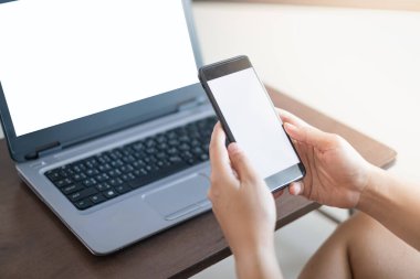 Çalışan konseptte akıllı telefon ve dizüstü bilgisayar kullanan kadınların elini kapat