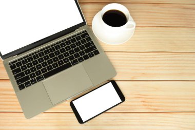 Kapalı ekran bilgisayarı, akıllı telefon ve sabahları iş için ahşap masaya bir fincan kahve. 