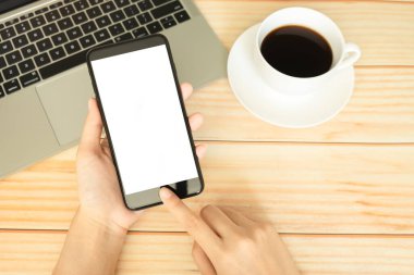 Akıllı telefon kullanan ve ev ofisinde kahveyle çalışan kadınlar. 