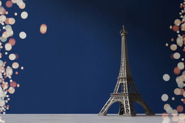 Souvenir Tour Eiffel sur fond bleu avec des lumières bokeh colorées comme cadre — Photo