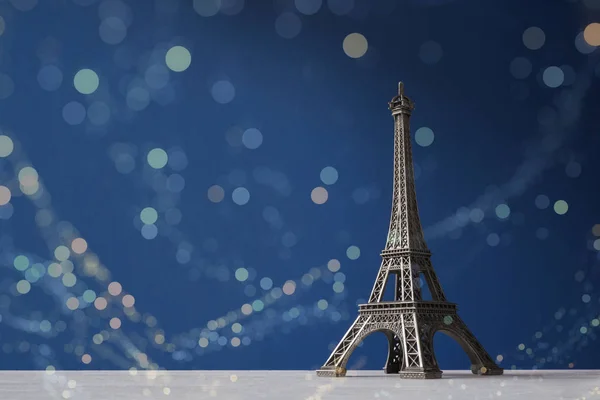 Souvenir Tour Eiffel sur fond bleu avec des lumières bokeh colorées — Photo