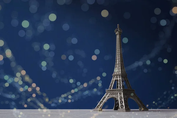 Souvenir Tour Eiffel sur fond bleu foncé avec des lumières bokeh colorées — Photo