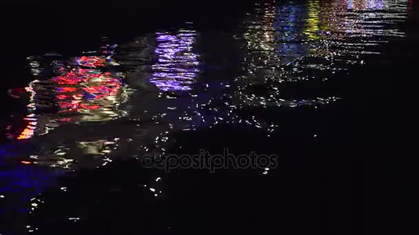 Mooie dynamische weerspiegeling van kleurrijke stad nachtverlichting in het zwarte water — Stockvideo