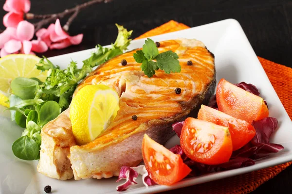 Slice of fresh salmon with tomatoes and salad — Stock Photo, Image