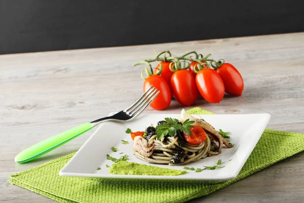 Spagetti siyah mürekkep balığının mürekkebi, maydanoz ve domates ile — Stok fotoğraf