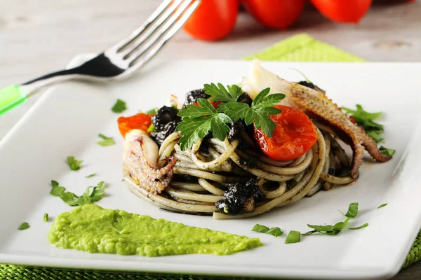 Spaghetti med svart sepia, persilja och körsbärstomater — Stockfoto