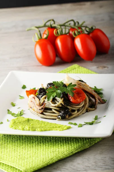 Spaghetti z czarny sepia, pietruszka i pomidorkami — Zdjęcie stockowe