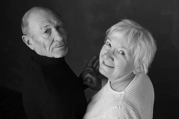 끝 없는 사랑의 초상화입니다. 실내 어두운 배경에 손 하기 손에 서 있는 동안 웃 고 서로 보고 행복 한 수석 커플의 흑백 초상화 — 스톡 사진