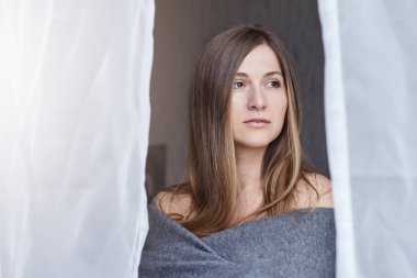 Erken sabah ateş yakın. Genç çekici beyaz bir kadın modern yatak pencere perdeleri üzerinden temiz hava teneffüs edilmesi. Sağlık ve güzellik kavramı.