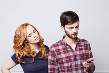 Cep telefonuna sms okuma, aşığı olduğu sinsi bir ifadeyle Elektronik Gadget ekrana bakarak onu casusluk iyelik güzel eşi mesajlaşma sakallı yakışıklı beyaz erkek