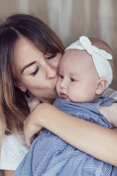 Madre joven con su niño de varios meses de edad, vestido con pijama, se relajan y juegan en el dormitorio el fin de semana juntos, mañana perezosa, escena cálida y acogedora. Enfoque selectivo . — Foto de Stock