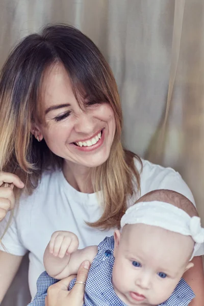 Madre joven con su niño de varios meses de edad, vestido con pijama, se relajan y juegan en el dormitorio el fin de semana juntos, mañana perezosa, escena cálida y acogedora. Enfoque selectivo . — Foto de Stock