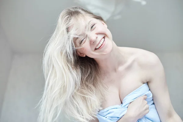 Nabídka vnitřní detail portrét krásné Kavkazský žena, pózování s happy smile v posteli ráno. Mladá atraktivní modré oči dáma má dlouhé blond vlasy hravě při pohledu na fotoaparát. Koncept zdraví a krásy. — Stock fotografie