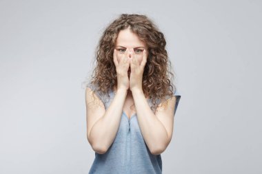  Üzgün erkek yorgun gevşek T-shirt ile yüzünü kaplayan eller Mavi giyen ve bitkin saç topuz ile hayal kırıklığına uğrattı. Umutsuz kadın ağlayan yüzünü elleri ile gizleme depresyon sahip