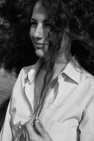 Красивый природный свежий и модный открытый черный белый вертикальный снимок нежной и потрясающий молодой счастливой женщины с великолепной улыбкой и вьющиеся вьющиеся длинные волосы в крупногабаритной рубашке. Селективный фокус . — стоковое фото