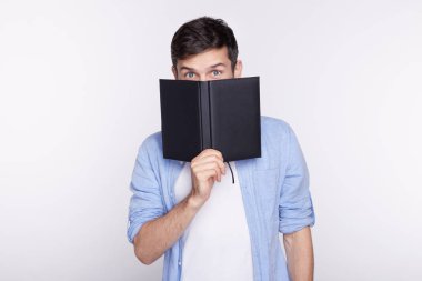 Avrupa mavi gözlü işadamı veya öğrenci stüdyo çekim rahat, defter mizahi kameraya bakarak beyaz zemin üzerine izole dururken arkasında yüz gizleme giyinmiş. İnsanlar, iş, kariyer.