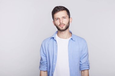 Erkeklik portresi. Yakışıklı genç sakallı hippi adam ciddi veya kızgın ayakta Studio boş duvar arka plan kopya alanı reklam içeriğiniz için looking-ile şık saç kesimi ile.
