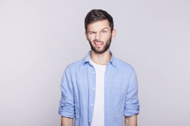 Duygusal ve şık genç beyaz mavi gözlü yakışıklı adam çalışan yapması, kamera birisi, küçük yaramaz çocuk gibi davranmayı takılmaya çalışıyorum, ağız yapma Beyaz tişört üzerinde mavi ceket.