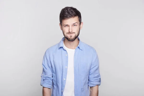 Cabeza de atractivo hombre europeo haciendo muecas, inflando sus mejillas, conteniendo la respiración, tratando de no reír, mirando a la cámara con expresión de cara divertida, payasadas y divirtiéndose en el interior . — Foto de Stock