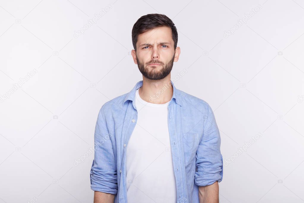 Human facial expressions, emotions and feelings. Studio shot of disgusted young blue eyed Caucasian man dressed casually, grimacing, looking in terror and disgust, feeling averse to do something.