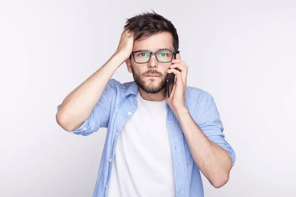 Oh, Dios mío. Expresiones faciales humanas, emociones, sentimientos. Bug-eyed elegante joven oficinista en gafas exclamando en shock, manteniendo la mano en la cabeza, sorprendido con algunas noticias inesperadas por teléfono . — Foto de Stock