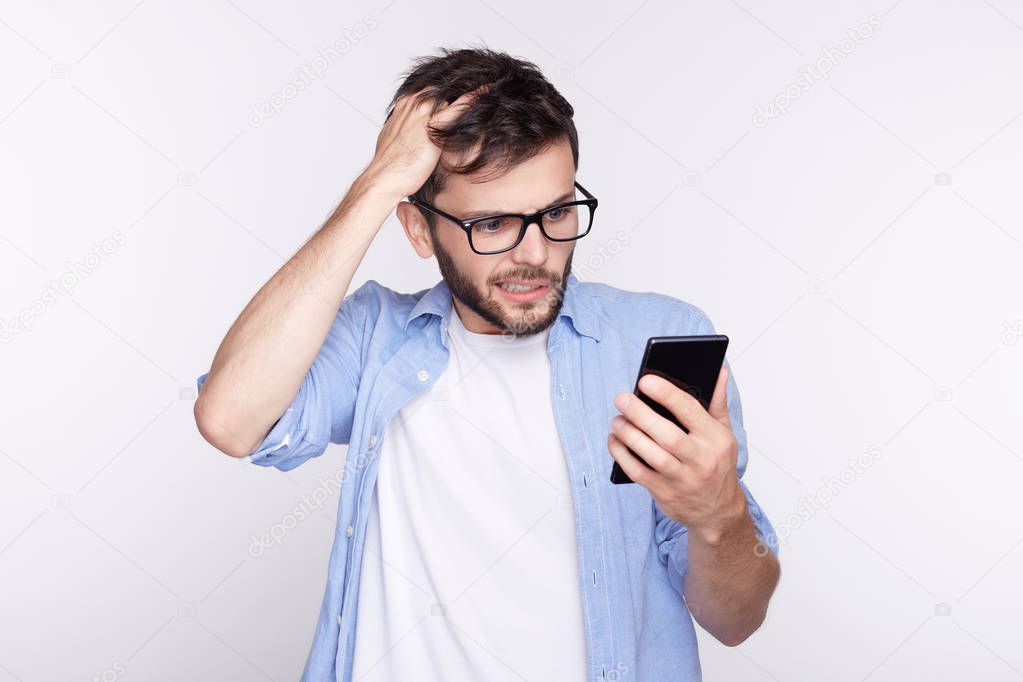 Handsome European blue eyed guy received provocative video from last night birthday party. Confused and surprised young bearded Caucasian hipster trying to remember name of lady who is calling him.
