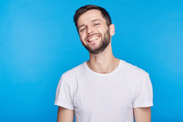 Handsome unshaven young European male laughing out loud at funny joke he heard on radio, smiling broadly, showing his white straight teeth. Positive human facial expressions and emotions concept. — Stock Photo, Image
