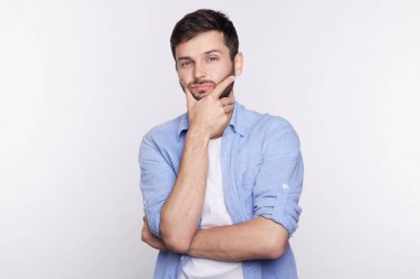 Şüpheli dalgın genç beyaz erkek ise bir şey yüzünden, yorgun düşünce ve çözüm bulmaya çalışırken yüz dokunmadan, olan çapraşık ve ifade şaşkın rahat t-shirt'portresi.