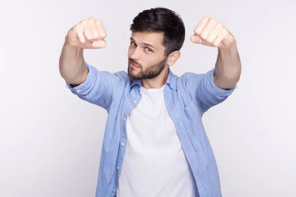 Feliz joven caucásico actuando como un jefe, rebosante de alegría y placer. Hombre guapo con ojos azules dobla sus puños en la mentalidad ganadora, luciendo coqueta, mostrando sus músculos perfectos y poder . — Foto de Stock