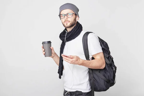 Pensativo barbudo europeo hipster tipo con sombrero de moda y camiseta, bebe café de la mañana, escucha melodías tristes como estar molesto extrañando a su novia, recuerda momentos agradables, disfruta de su viaje . — Foto de Stock