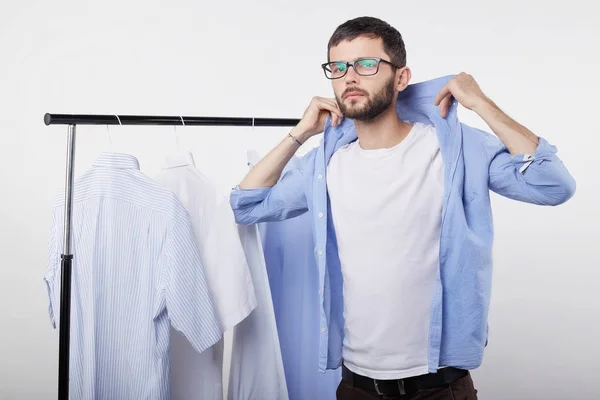 Retrato de elegante confiante jovem blogueiro de vídeo masculino montagem nova camisa em camarim privado para tiro tutorial para seu vlog viajando. Homem europeu na moda tentando roupas novas na loja . — Fotografia de Stock