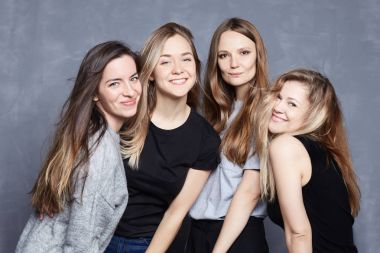 Sevgi ve dostluk kavramı. Şehvetli studio sevinç ve olumlu duygular ifade ile yüzleri, mutlu gülümseyerek poz dört genç Avrupa Bayanlar vurdu. Çekici kadın neşeyle kameraya bak. 