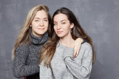 İki karma yarış arkadaş nazik olan Studio'da poz kadın birbirlerini görmek için memnun gülümse. Genç sarışın beyaz kadın güzel Asya eşi ziyaret edin ve resmi birlikte almak mutlu olmak.