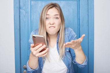 İnsanlar, saldırganlık, duygular kavramı. Kızgın kızgın sarışın kadın rahat kot giyer, aktif olarak jestleri, onun tüm ofis işi tek başına yapmak meslektaşları ile bir sorunum var. Duygusal erkek kuduz.