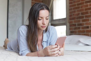 Hareket eden telefon, ekran, sörf sosyal ağlar, Gadget'ı izlemek için dikey alarak hikayeler popüler uygulamasında düzenleme yaparken müzik dinlemek dikkatle bakarak tutmak şık kadın modeli. 