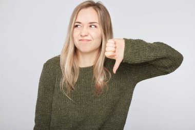 Sevmediğim, ret, ifade şık giyim rahatsız ve tiksinti genç Avrupa kadın portresi Studio saygısızlık veya başparmak aşağı gösterilen ve ekşitmeden jestleri ile göz ardı.