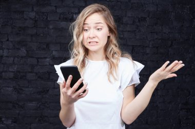 Akıllı telefon kısa mesaj onu faturaları hatırlatmak hakkında hemen borçları ödemek gerekiyor kızgın tahriş kadın okur, memnuniyetsizlik, ifade büyük öfke ve öfke, frowns yüzüne darbeler Buhar.