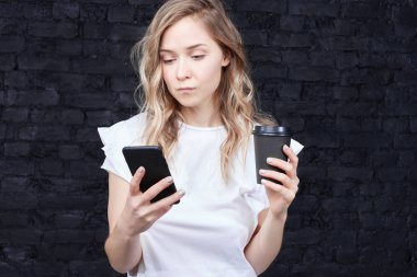 Yüksek hızda kablosuz internet bağlantısı zevk, arkadaş mesajlaşma ve resimler online sosyal ağlar üzerinden tarama, kahve alarak güzel beyaz kız öğrenci rahatlatıcı, samimi atış.