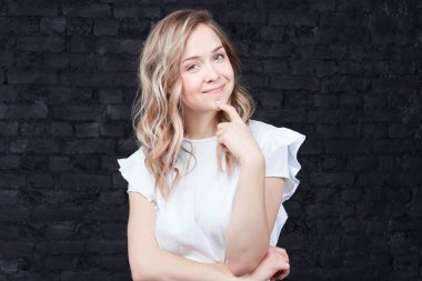 İnsanlar ve yaşam tarzı kavramı. Elini çenesinin üzerinde tutarak ve kameraya kurnaz gizemli bir ifadeyle, büyük fikir geliyor seyir çekici Bayan büyüleyici esrarengiz gülümsemeyle yatay çekim.