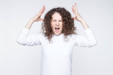 Genç güzel Avrupa genç kadın diş çaresizlik içinde clenches, beyaz arka plan üzerinde izole rahat t gömlek giymiş bir şey hakkında üzüntü duyar. İnsan duygu ve duyguları kavramı negatif.