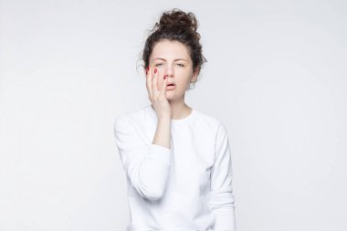 Yorgun komik kız öğrenci eğitimi ile kapakları yüz, bıkmış hiçbir şey duymak istemiyor, sınav başarısız sonra hayal kırıklığına uğramış, üzerinde beyaz stüdyo duvar, kopya alanı reklam için izole.