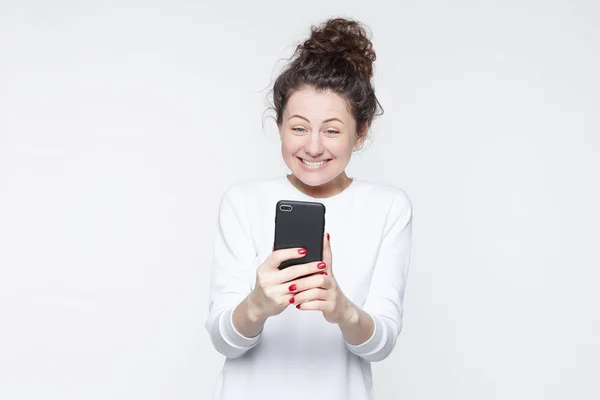 Aufgeregtes Weibliches Model Erhält Unerwartete Nachrichten Oder Nachrichten Telefon Blickt — Stockfoto