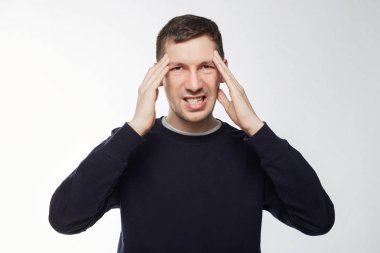 Dişler, tutarak şok erkek portresi korkmuş görünüyor, tapınaklar, duymak şaşkın ellerinde tutar Haberler, şok edici kötü kader, pozlar kopya alanı ile beyaz stüdyo duvara içinde inanamıyorum.