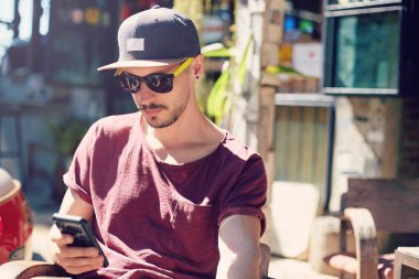 Her zaman görüşüyoruz. Şık gözlüklü ve şapkalı özgüvenli bir adam akıllı telefondan e-posta kontrol ediyor, internet üzerinden bağış yapmak için mobil bankacılık başvurusu yapıyor, açık hava kafeteryasında oturuyor..