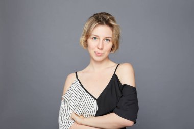 Kısa sarı saçlı, hoş görünümlü bir bayan. Tereddüt ediyor, dudaklarını bastırıyor, kameraya bakıyor ve karar vermeye çalışıyor. Açık tenli kadın model, hiçbir fikri olmayan bir şey için endişeleniyor..