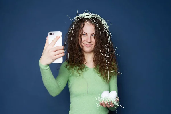 Frohe Europäerin Mit Angenehmem Lächeln Schaut Die Handykamera Hält Ostereier — Stockfoto