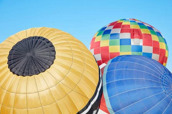 Balões de ar quente coloridos inflando no chão, céu azul — Fotografia de Stock
