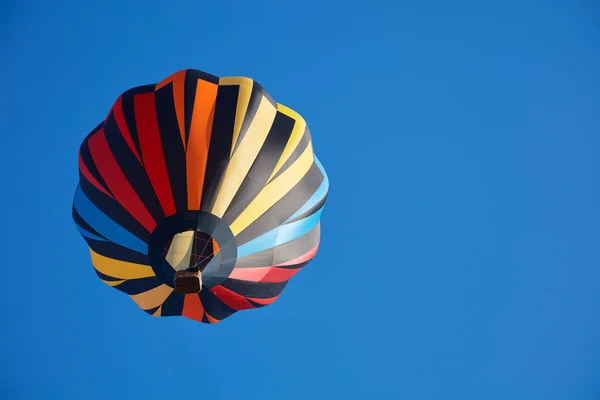 Varmluftsballon, en farverig aerostat, blå himmel - Stock-foto